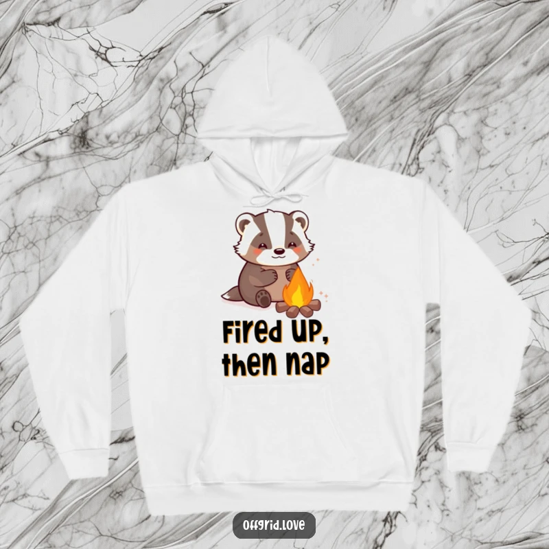 Funny hoodie featuring a contented badger basking in the glow of a small campfire, exuding comfort and happiness.